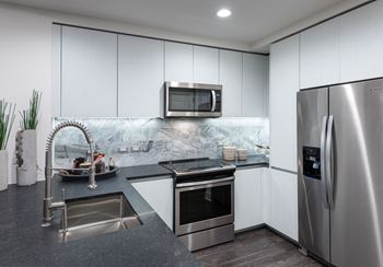 Granite and quartz countertops with full-height backsplash  at Stanza Little Italy, San Diego, CA